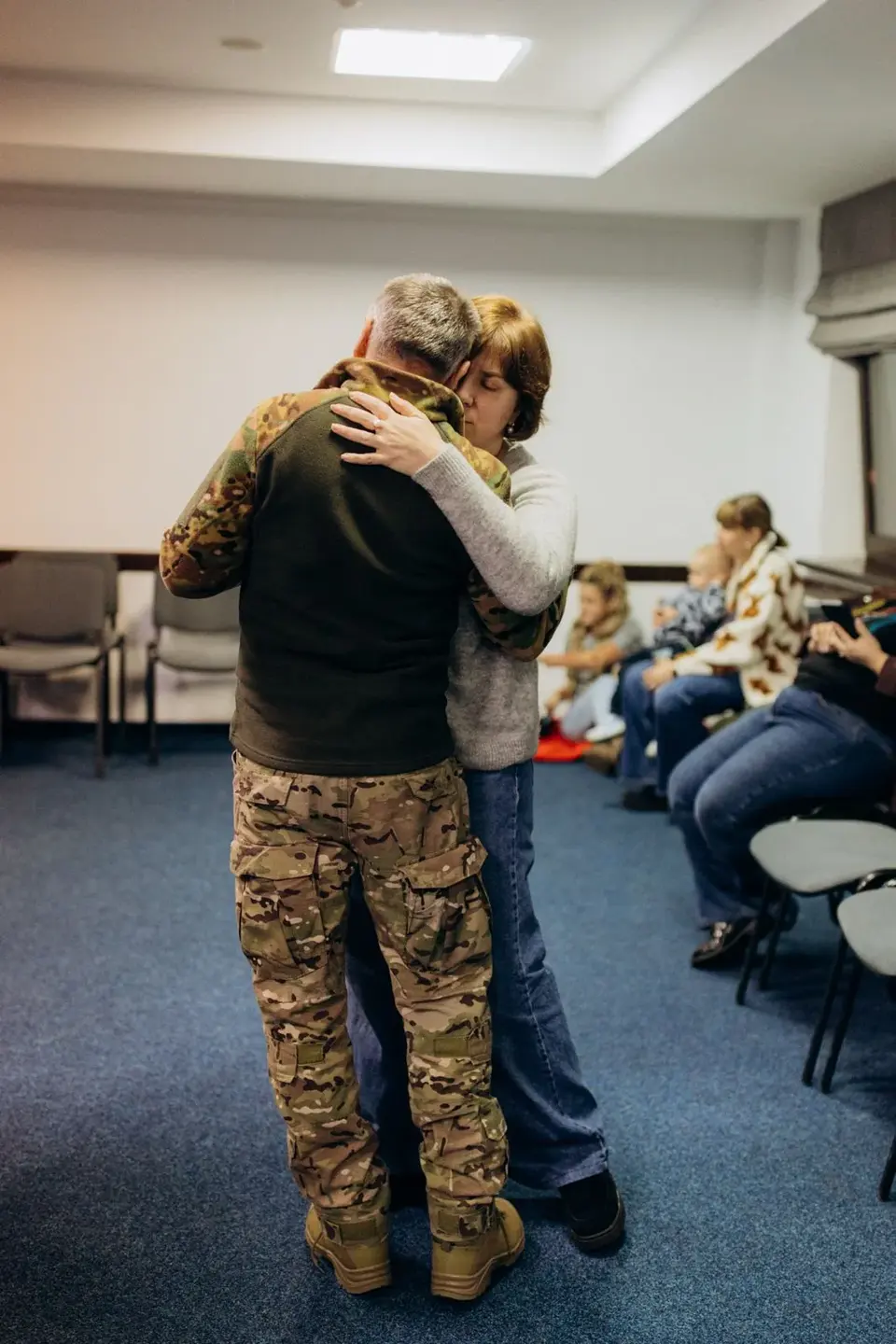 A married couple embracing during a family gathering